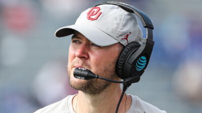 Lincoln Riley in a hat and headset