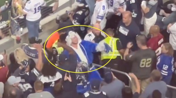 A Cowboys fan is escorted out of the game
