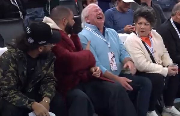 A Thunder fan laughs next to Drake