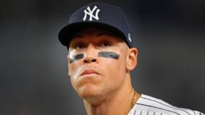 Aaron Judge looking on while wearing a Yankees cap