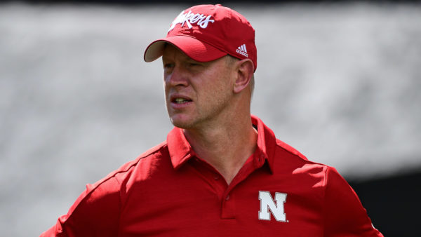 Scott Frost in a Nebraska polo and hat.