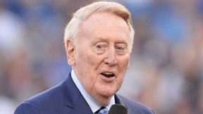 Vin Scully holds a mic