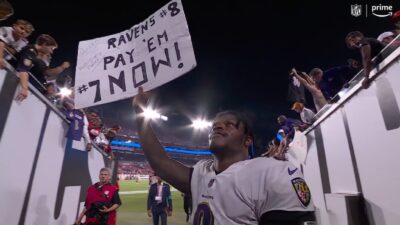 Lamar Jackson holds up a sign
