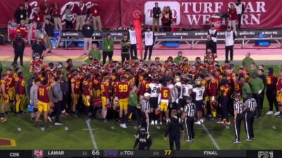 USC players gather around Travis Dye