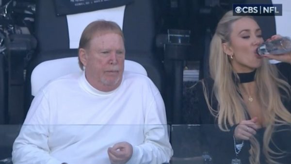 Mark Davis sits with a woman in his luxury box