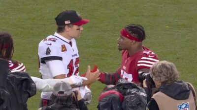 Tom Brady and Dre Greenlaw shake hands