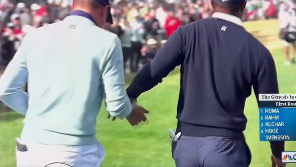 Tiger Woods hands something to Justin Thomas