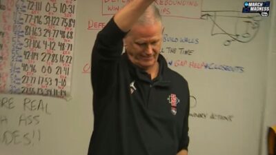 Brian Dutcher standing in front of a board