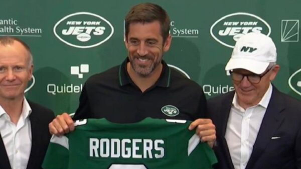 Aaron Rodgers holds up a Jets jersey