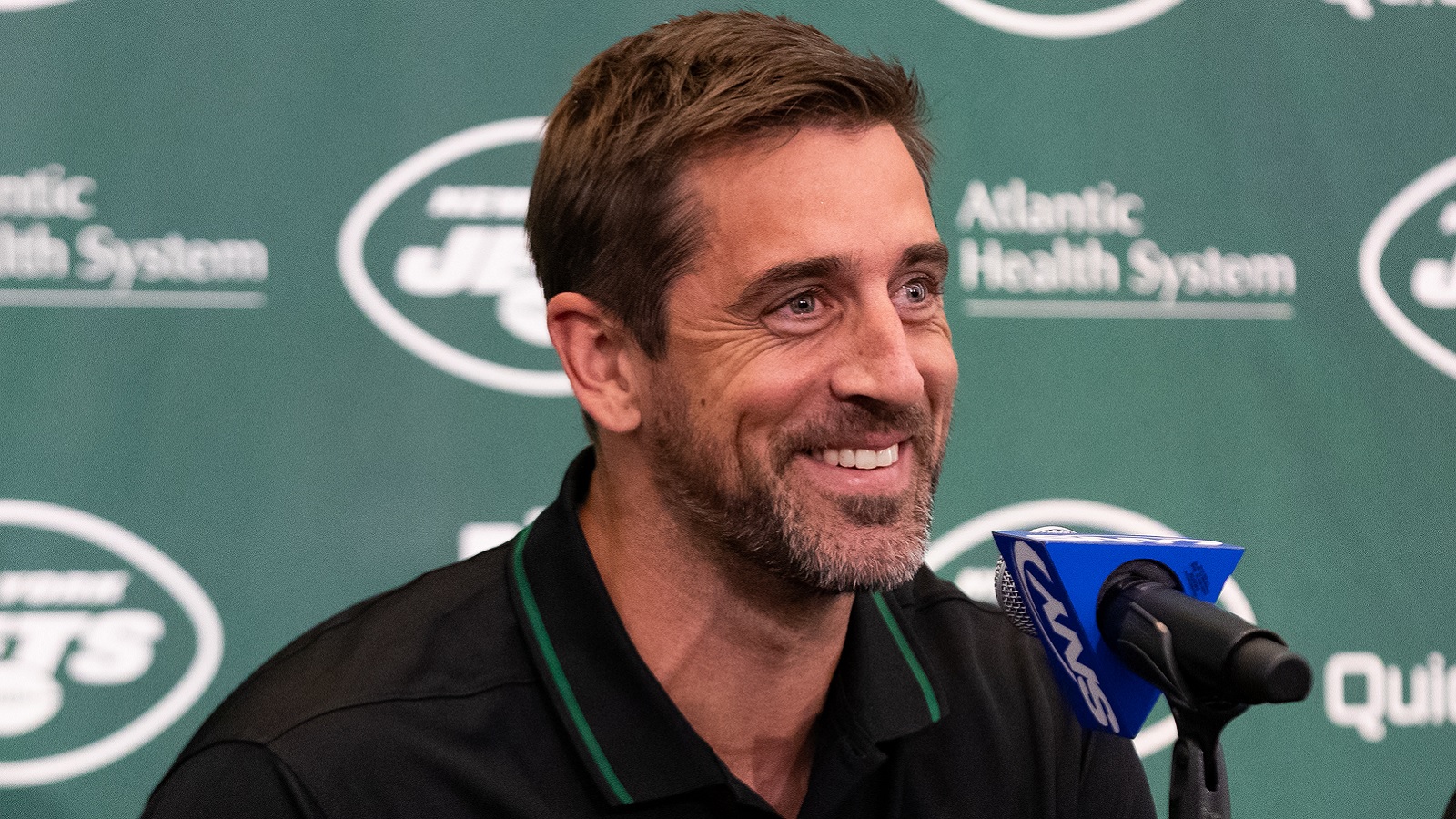 Aaron Rodgers smiling at Jets presser