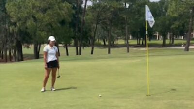 A golfer watches a putt roll back to where it was hit from
