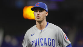 Cody Bellinger in a Cubs hat looking on