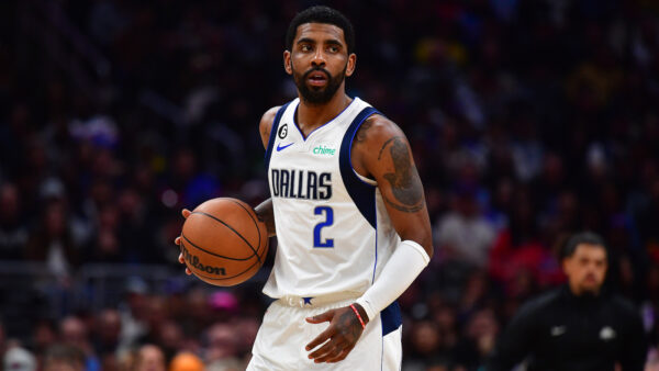 Kyrie Irving in Mavs uniform holding a basketball