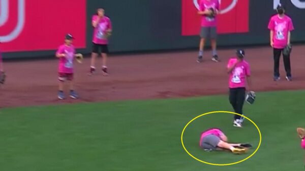 A kid on the ground in the outfield