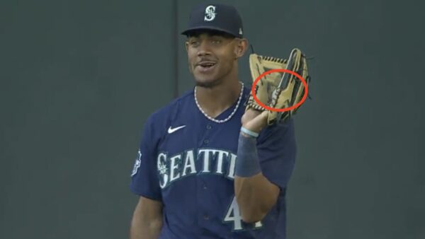 Mariners outfielder Julio Rodriguez hiding a baseball in his glove 