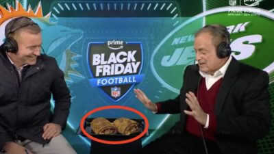 Al Michaels looking at a sandwich