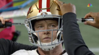 Christian McCaffrey getting his helmet readjusted during 49ers-Seahawks game