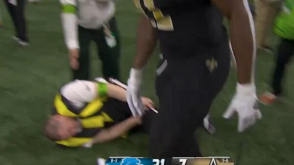 A sideline official grabs his leg in pain