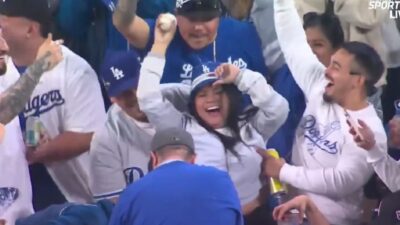 A Dodgers fan holding up Shohei Ohtani's HR ball