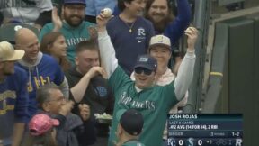Mariners fan holds up two foul balls he caught