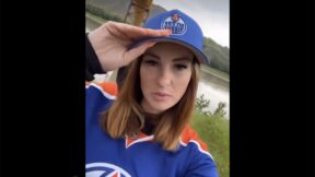 Famous Oilers fan Kate holding her cap