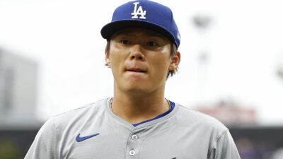 Yoshinobu Yamamoto holding a Dodgers cap