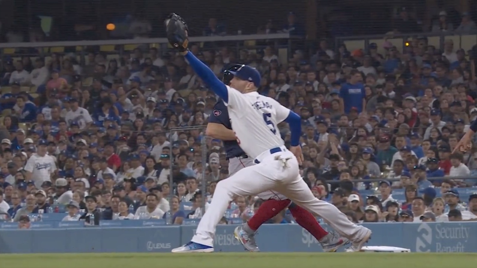 Dodgers first baseman Freddie Freeman attempts to field a throw to get Red Sox baserunner Tyler O'Neill out