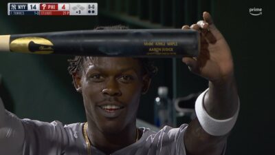 Yankees player Jazz Chisholm holding up Aaron Judge's bat