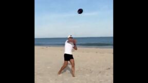 Tom Brady throwing a football on the beach
