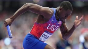 Christian Coleman runs with the baton in a relay race