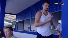 Nikola Jokic holding a beer at a horse racing event