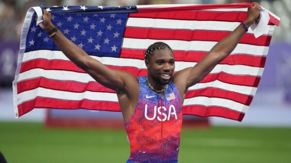 Noah Lyles carrying the American flag