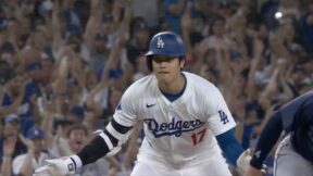 Dodgers star Shohei Ohtani celebrating after sliding into third base with a triple