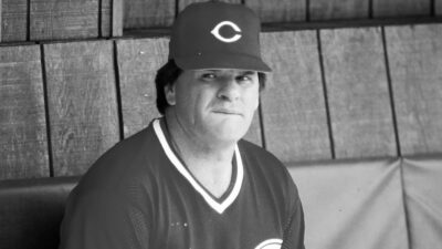Pete Rose sitting in the Reds' dugout