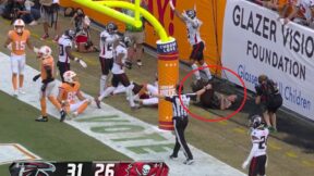 An officer at the Buccaneers game getting knocked down