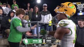 Oregon tight end Kenyon Sadiq playing rock-paper-scissors with a fan