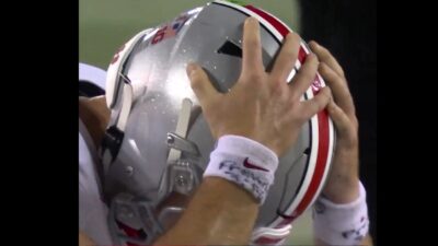 Will Howard with his hands on his helmet