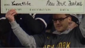 A New York Yankees fan holding up a Juan Soto sign