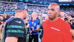 DeMeco Ryans walks by Aaron Rodgers