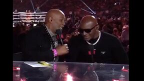 Lennox Lewis whispering to Evander Holyfield during Mike Tyson-Jake Paul boxing event