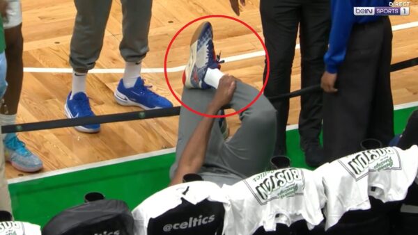 Joel Embiid holding his ankle in pain