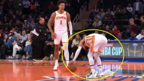 Trae Young hunched over the New York Knicks logo