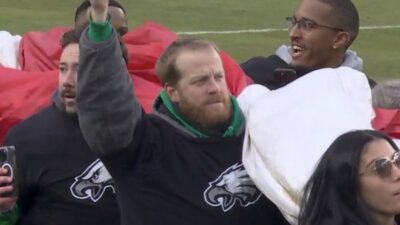 An Eagles flag carrier holds up the book AJ Brown read