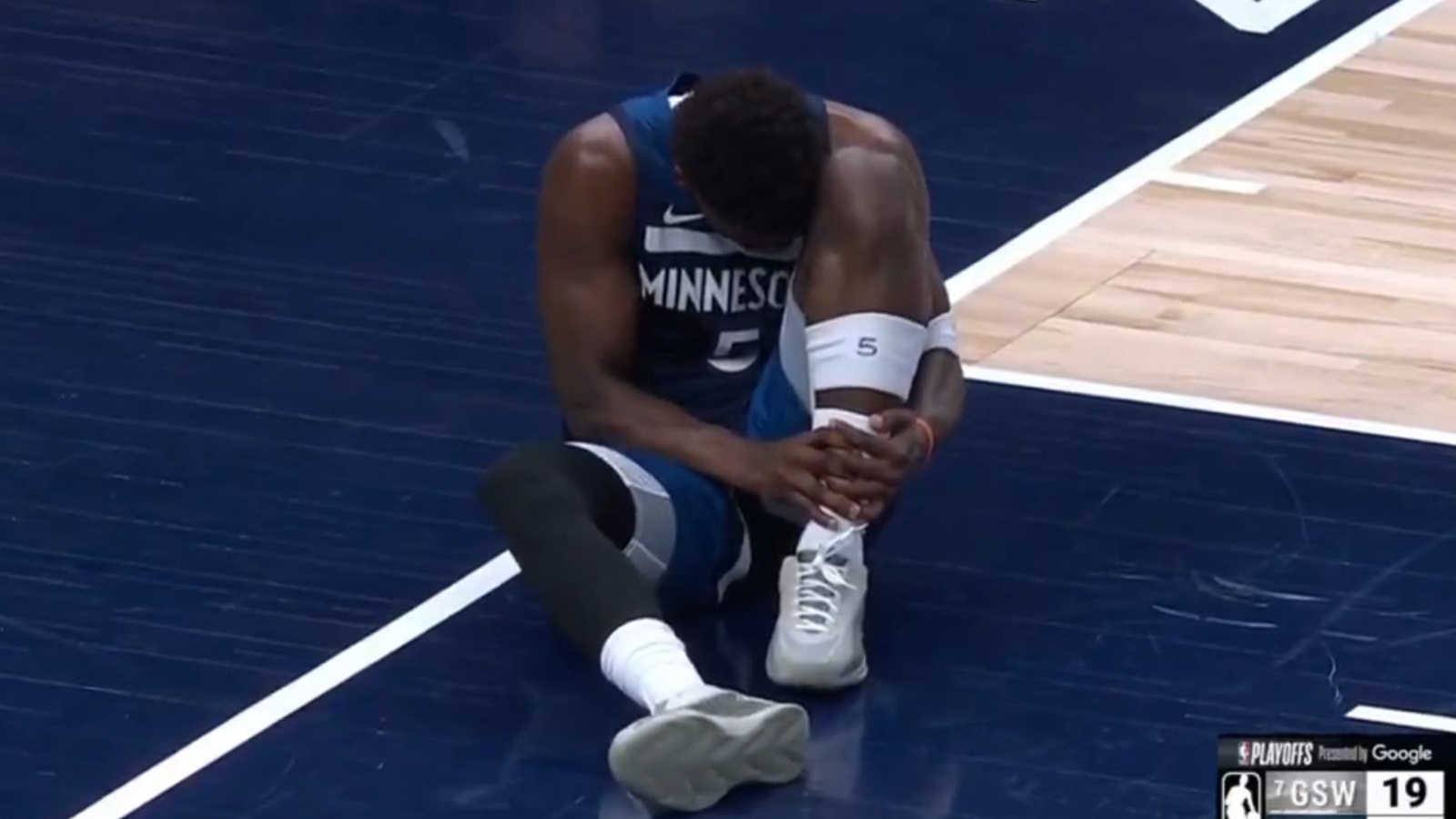 Anthony Edwards holding his ankle in pain