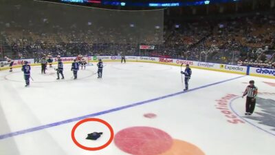 Maples Leafs fan throws a jersey onto the ice