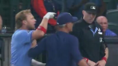 Taylor Walls is restrained from going after an umpire