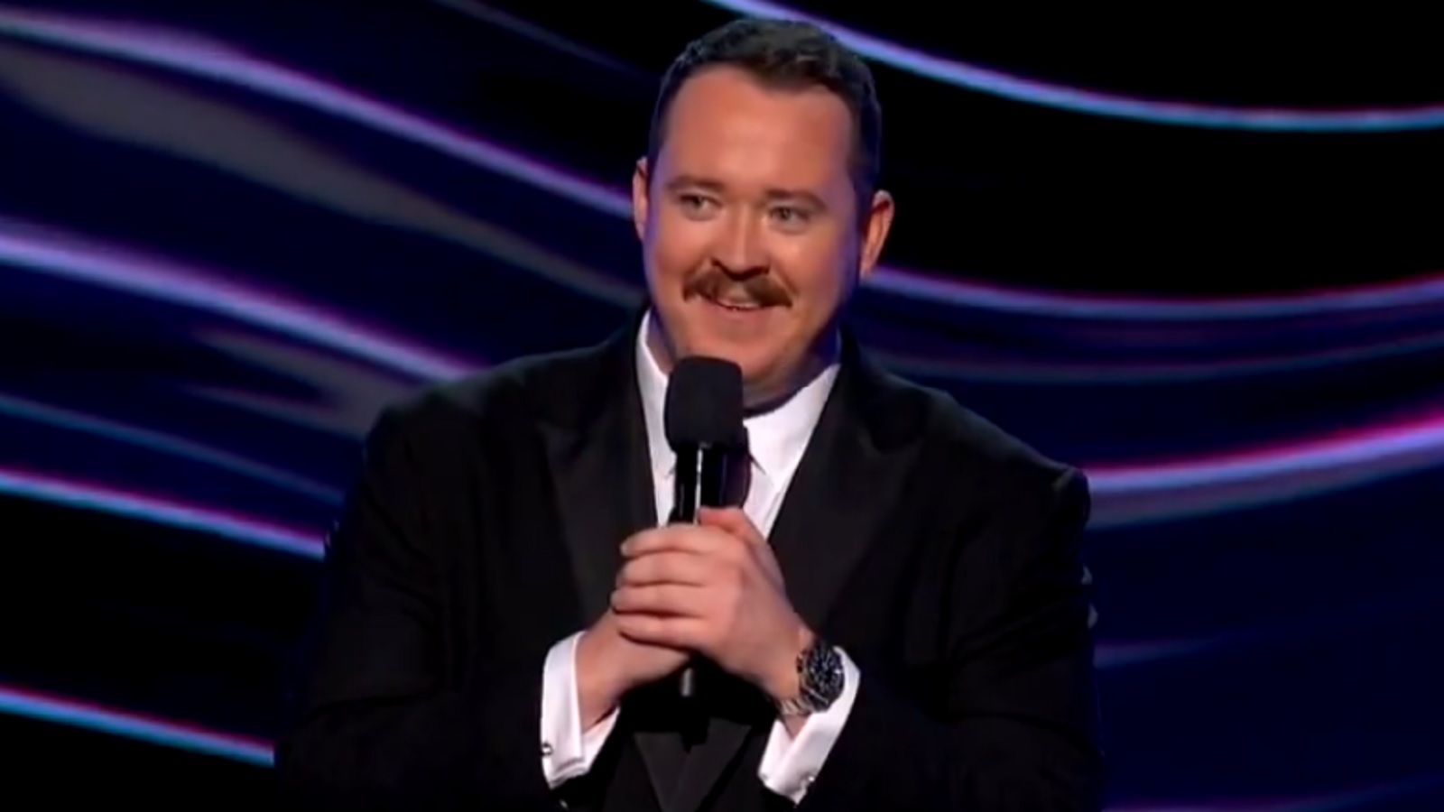 Shane Gillis holds a microphone
