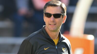 Derek Dooley looks on