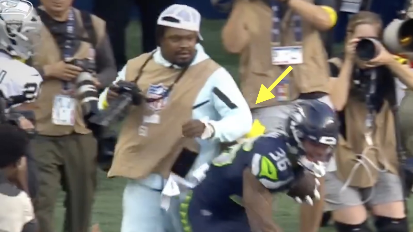 Marshawn Lynch throws an elbow while working as a photographer