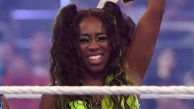 Naomi raises her championship belt in the air
